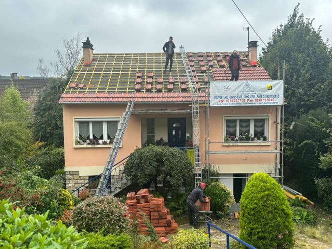 Rénovation complète d'une toiture en tuiles mécaniques, l'équipe sur le toit d'un pavillon