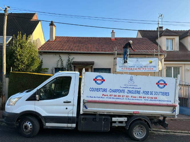Camion de l'entreprise devant une maison en cours de réparation de toiture