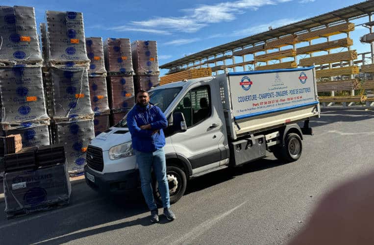 Kevin Paumard devant son camion chargé de palettes de tuiles