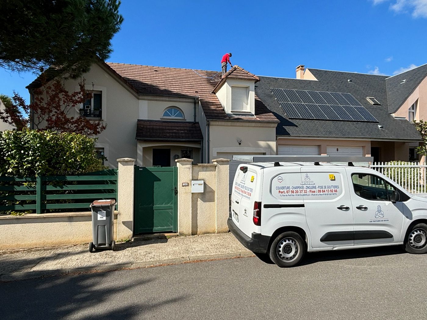Couvreur en train de nettoyer la toiture d'un pavillon à Nozay, camionnette de l'entreprise devant la maison