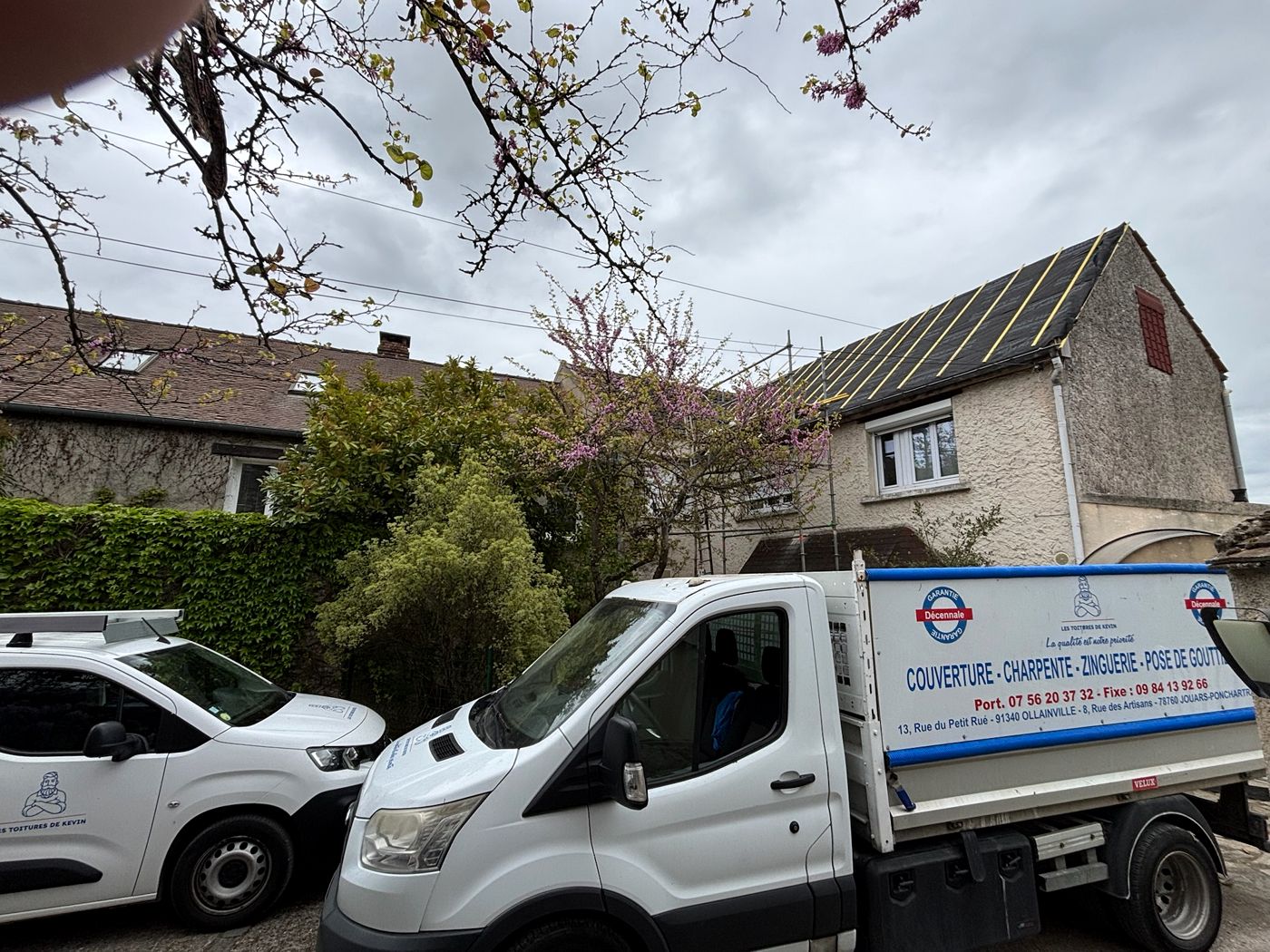 Grand versant de la maison sur écran sous-toiture et liteaux neufs, camion de l'entreprise devant, à La Norville