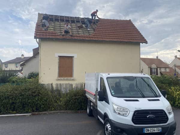 Véhicule Les Toitures de Kevin devant un chantier de rénovation