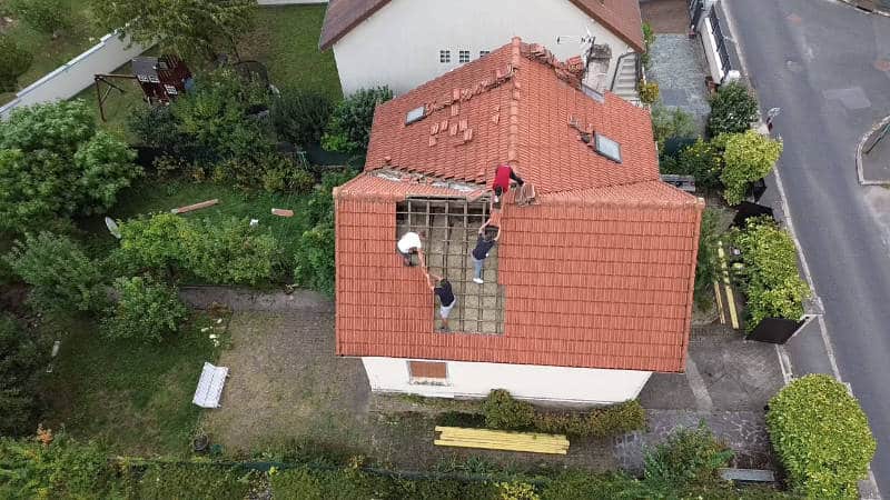 Vue aérienne d'une intervention de réparation sur une toiture en tuiles